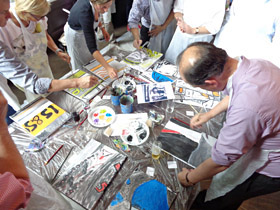 Workshop puzzelschilderij, schilderij maken bestaande uit een aantal kleine doeken, een foto wordt in stukken geknipt, iedereen krijgt een puzzelstukje, samen wordt dit een groot schilderij, in di geval met het thema reiziger voor de ns